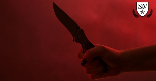 man holding a knife with a red background