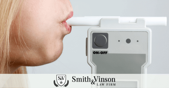close up of woman blowing into breathalyzer machine for DWI